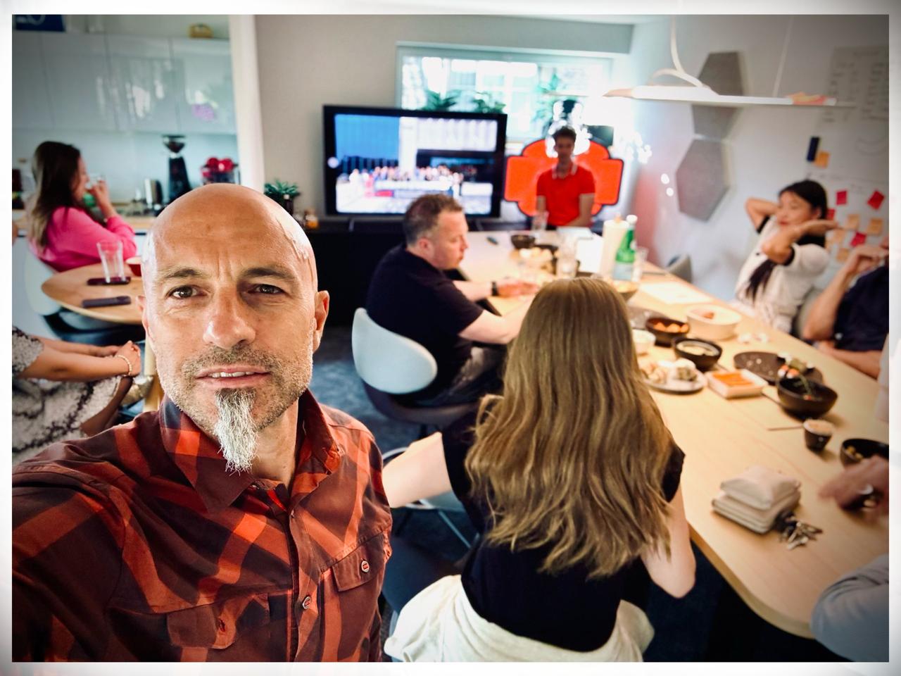 Xaver takes a selfie with the room gathered around the table at Ship26